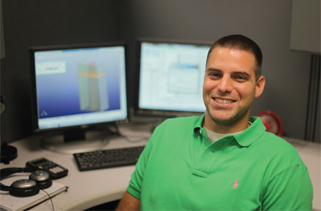 photo of Eric Sammarco smiling in front of computers